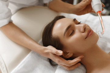 Obraz na płótnie Canvas Face Beauty Treatment. Woman Using Darsonval Skin Care Device