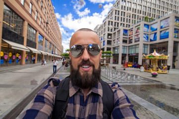 bearded photographer make selfie on the city background, self po