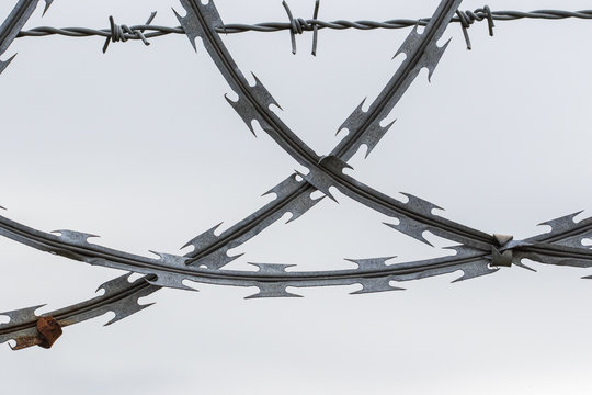 Close up of crossed pieces of razor and barbed wire