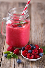 Healthy smoothie with raspberries, berries on plates and drinkin
