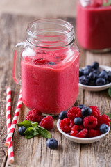 Healthy smoothie with raspberries, berries on plates and drinkin