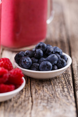 Plates with berries and smoothie background.