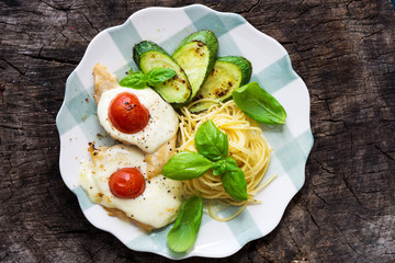 Italian lunch: chicken with mozzarella ,spaghetti and zucchini