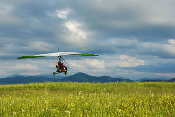 Glider flying over the grass