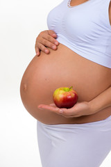 Pregnant woman holding an apple in her hands. Diet, vitamins and healthy food during pregnancy