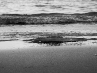 Out of focus abstract sea wave at shore creates interesting texture in black and white