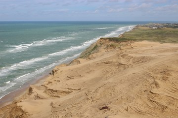 View of the North Sea and of huge sand dunes, North Jutland, Denmark. In the background one can see the village Lonstrup. Seen from the top of the lighthouse Rubjerg Knude fyr.