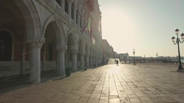 VENICE, ITALY - JUNE 19, 2016: Parking gandolas on the Doge's palace embankment with the bell tower of the Saint Giorgio Maggiore church view, Venice, Italy.