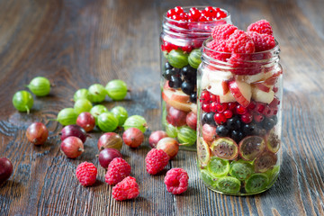 Summer berries smoothie in mason jar on rustic wooden table
