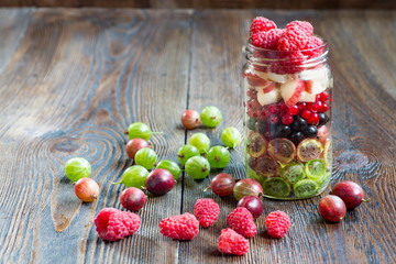Summer berries smoothie in mason jar on rustic wooden table