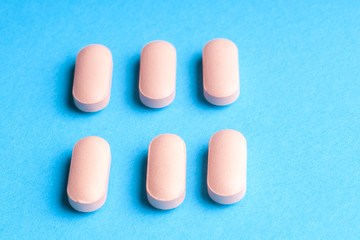Many pills and tablets isolated on light blue background