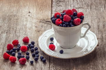 Raspberries and blueberries in ceramic bowl