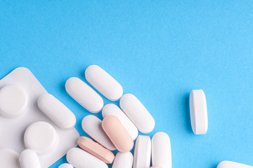 Many pills and tablets isolated on light blue background