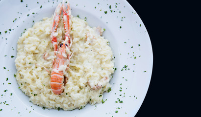 Seafood risotto dish with a big prawn on top