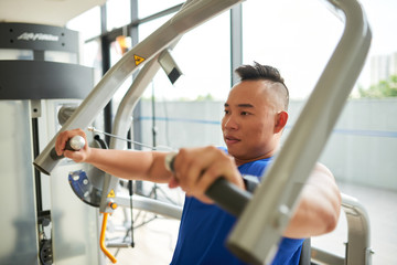 Vietnamese young man having training in gym
