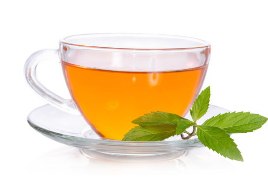 Glass cup of tea with mint on white