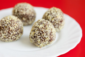 Delicious chocolate brownies sprinkled with coconut crumbs on a white plate. Selective focus, very shallow depth of field