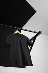 Bottom view on blank cotton t-shirt presented on massive crossfit pullbar in gym