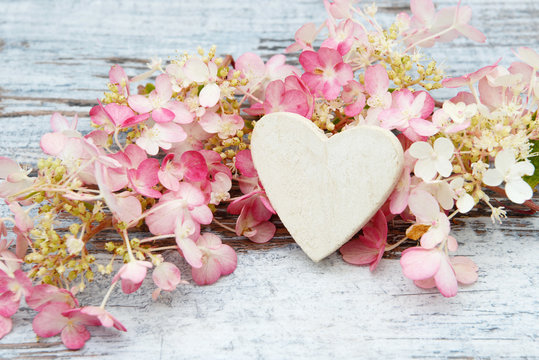 Flower And Wooden Heart Lying On Wood