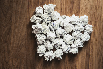 Heart shape made of crumpled paper, on wooden texture, vintage tone