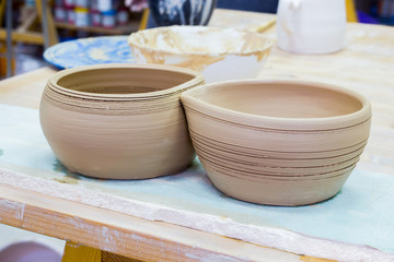 two ceramic clay bowl, blank, stand on a table in a pottery workshop