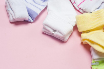 Cotton baby socks for newborn on a colorful pink background. Copy space for text. Top view