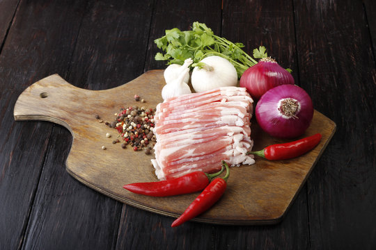bacon with vegetables on wooden background