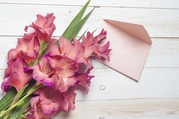 Colorful flowers in envelope, the word love, on wooden table, delivery concept. congratulate