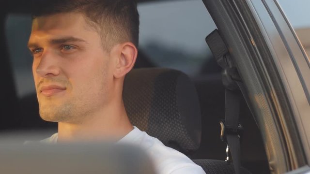 portrait of a young man behing the wheel, slow-motion