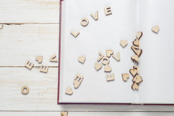 The word love a lot of hearts on a background of book on a wooden table. Back to school copy space. Education background.