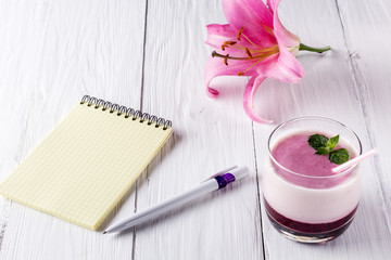 Berry smoothie with yogurt and notepad