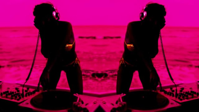 female DJ plays at the beach at sunrise