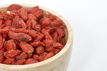 goji berry in wooden cup on white background.