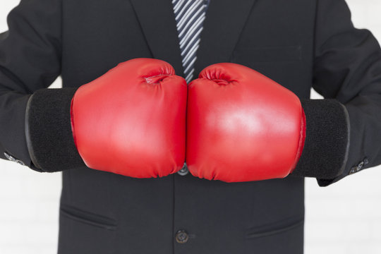 businessman in suit with red boxing gloves