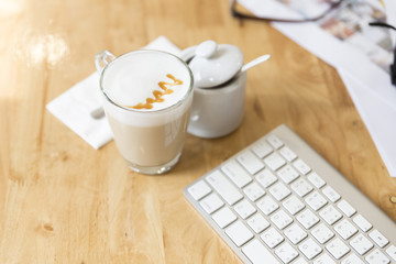 computer keyboard with hot cappuccino coffee drink with sugar mu