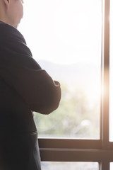 businessman in suit looking through office window