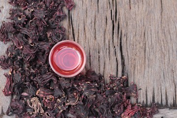 Dry roselle and roselle juice on wood background.