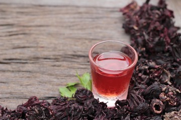 Dry roselle and roselle juice on wood background.