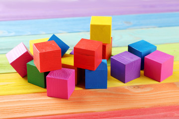 Obraz premium Colorful wooden toy cubes on a colorful wooden background