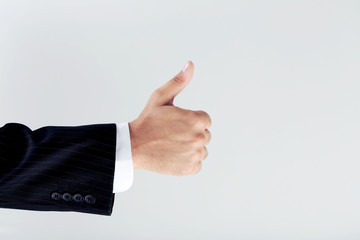 Businessman gesturing thumbs up on grey background