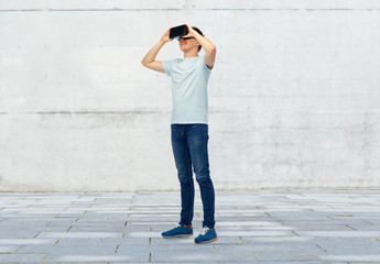 Fototapeta na wymiar happy man in virtual reality headset or 3d glasses