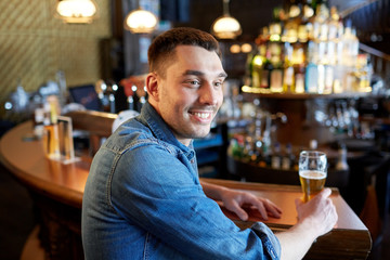 happy man drinking draft beer at bar or pub
