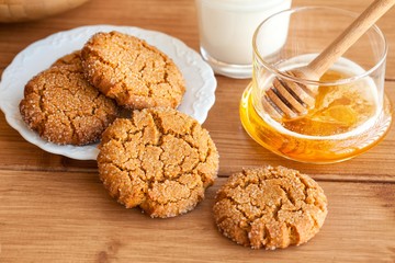 Honey ginger cookies with milk on a rustic background, selective focus