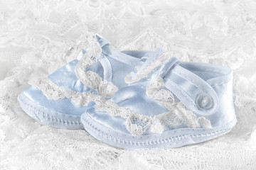 Blue baby booties on a lace background