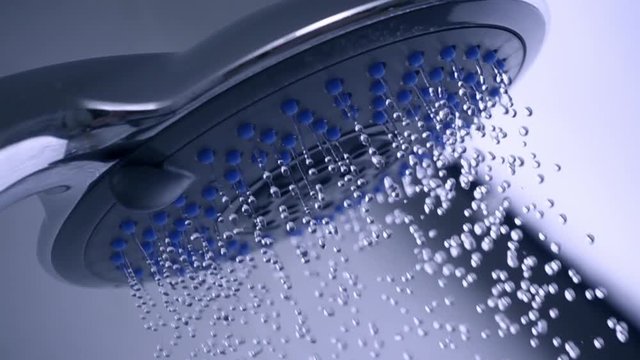 Slow motion shot of shower head with flowing water
