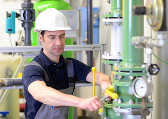 Monteur in einer Industrieanlage bei der Wartung und Reparatur // Mechanic in an industrial plant...
