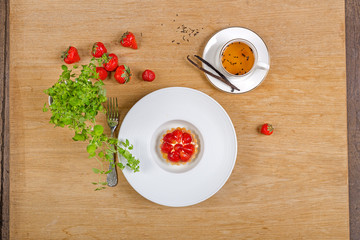 strawberry cake with tea and cinnamon on wooden background