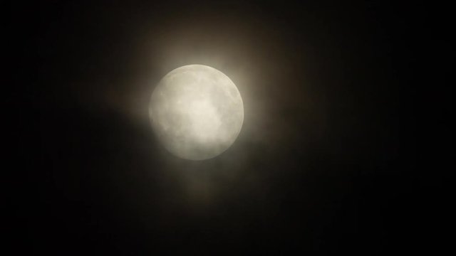 a full moon moving across the sky