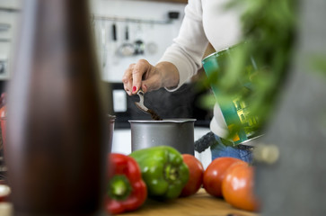 Woman making coffee with de focused things on the first plan