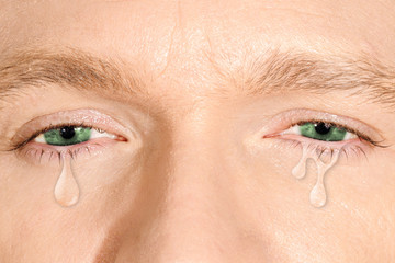 Crying green eyes of caucasian white man. concept of sadness,fear, love pains, mental depression disease,  eyewash and eye health 